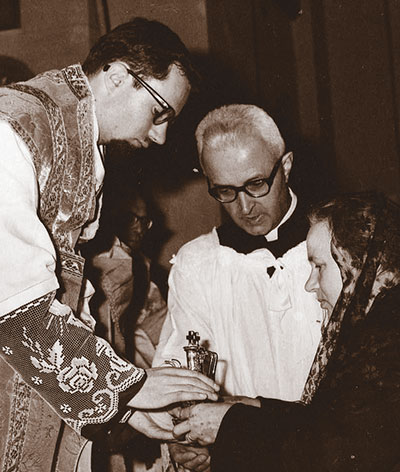 La prima Messa di p. Dante Volpini nel 1964, con il camice tessuto e ricamato da mamma Anna, che porta al figlio sacerdote le ampolline all'offertorio.