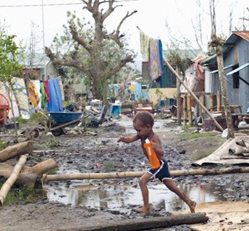 Corsa tra le macerie dopo il passaggio del ciclone Pam, a Vanuatu, nel Pacifico.